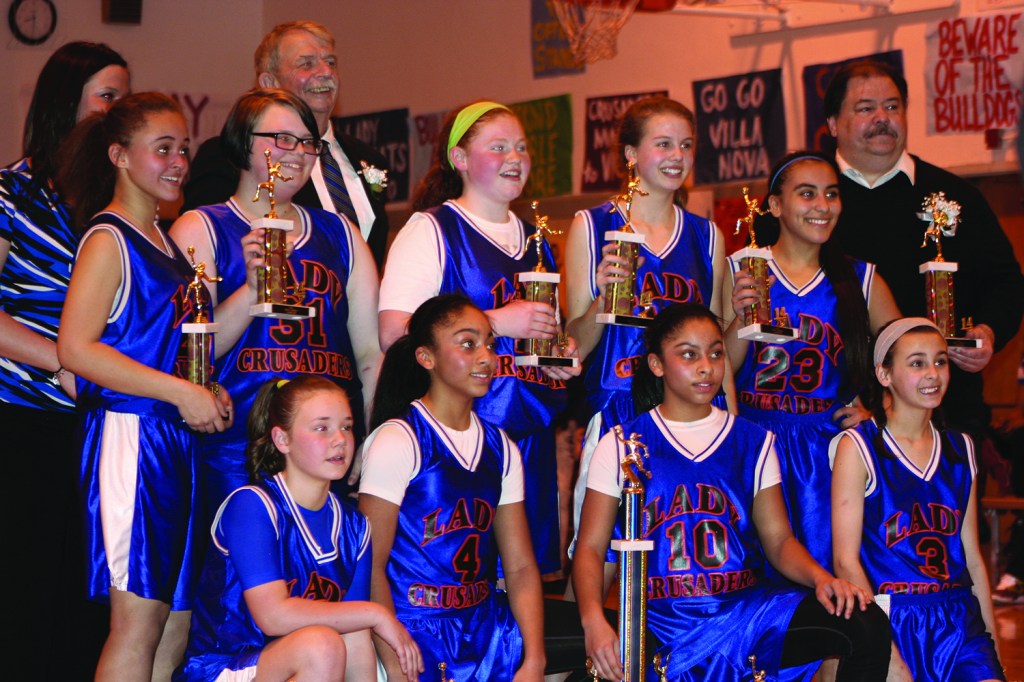 PHOTO BY CHUCK HOVEN Saturday, March 15, 2014, Girls Varsity League Ignatius Basketball Association Championship Game, St. Ignatius of Antioch School Gym, 10205 Lorain Ave: Members of the Holy Cross Lady Crusaders with their coaches after receiving their championship trophies. Team members are: Alyssa Dolan, Serena Saba, Jenine Saba, Grace Hoch, Maggie Wagner, Jocelyn Helmick, Alaysha Iwayis, Alandia Strong, and Abigail Staniszewski. The coaches are: Michelle Dreamer, Steve Hanigosky and Phil Swinderman.