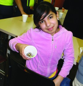 PHOTO BY CHUCK HOVEN Thursday, March 20, 2014, Fulton Branch, Cleveland Public Library, 3545 Fulton Road: Students from afterschool program of The Salvation Army’s Ohio City branch participate in a science program taught by staff of the OSU Extension Service. Jecely Torres, age 12, proudly shows a plant she grew from a seed that is now just starting to sprout.