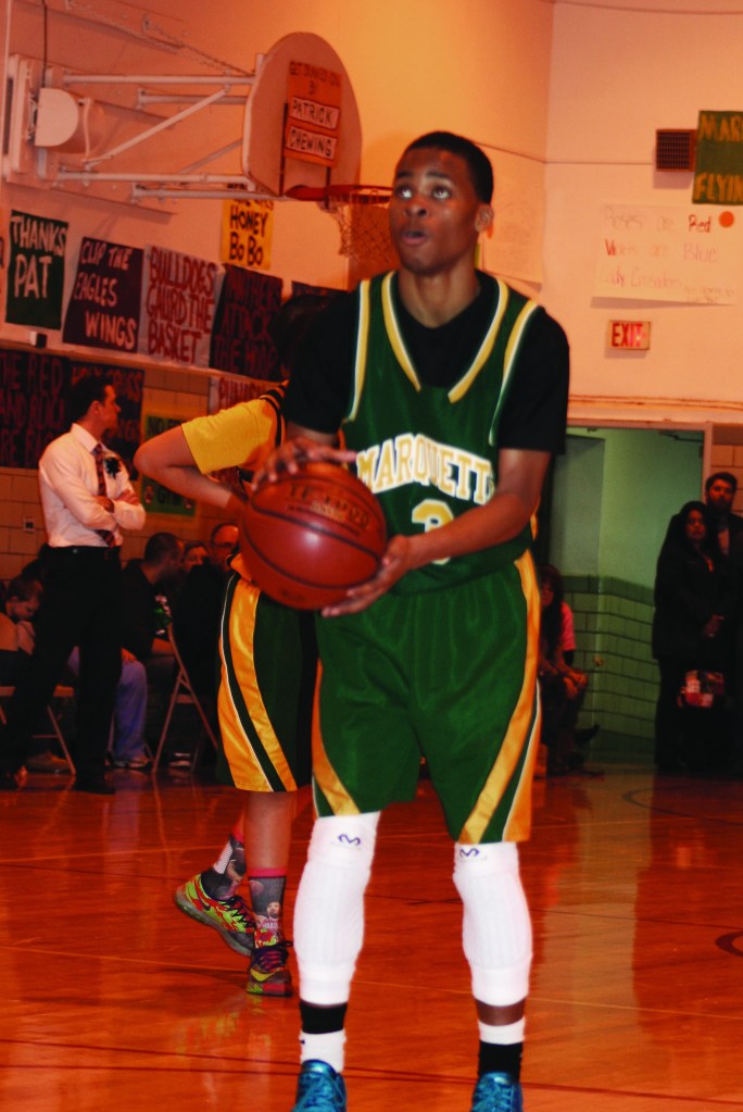 PHOTO BY CHUCK HOVEN Saturday, March 15, 2014, Boys Varsity League Ignatius Basketball Association Championship Game, St. Ignatius of Antioch School Gym, 10205 Lorain Ave: Delshawn Jackson of the Marquette team goes to the line to take a foul shot. The score in the contest was close throughout with Marquette holding a slim lead late in the game when Jackson fouled out. Without his defensive presence, Holy Cross surged ahead to win the championship by a score of 47-42.