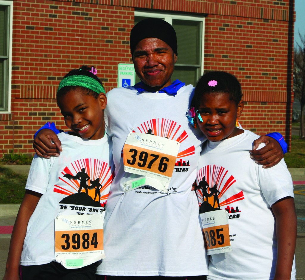 PHOTO BY CHUCK HOVEN Saturday, April 12, 2014; Be Your Own Hero 5KRace and 1 mile run, West Side Community House, W. 93rd and Lorain Avenue: Twins Rahaiila Kimolo, age 9, and Raiifa Kimolo, age 9, and Amina Abdulhaqq (center), a former West Side Community House Employee who now is a Social Worker with Catholic Charities Refugee Services. Rahaiila and Raiifa came in first and second in their age group in the one-mile run. 