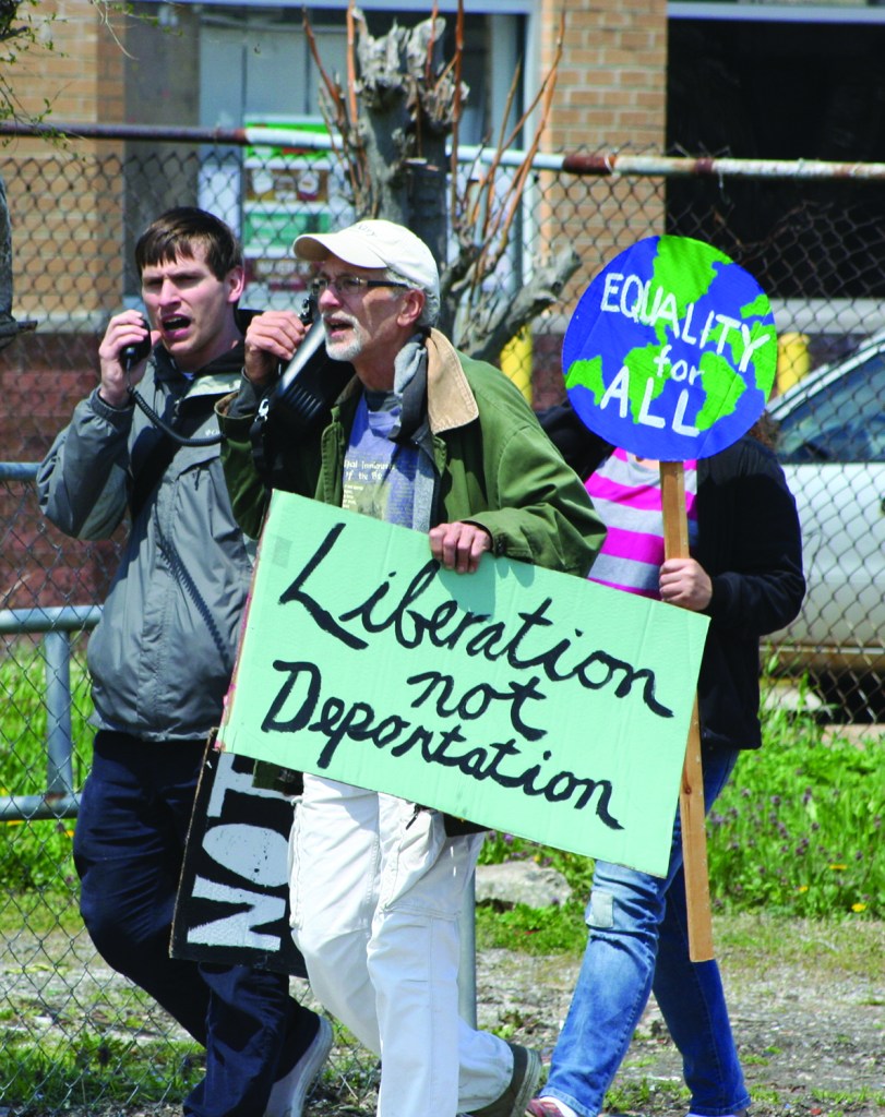 PHOTO BY CHUCK HOVEN Saturday, May 3, 2014; The Immigrant Justice Solidarity Rally and March organized by the Greater Cleveland Immigrant Support Network: Don Bryant. forefront, holds a sign saying “Liberation not Deportation, as marchers proceed down W. 25 as they march through the Clark-Fulton neighborhood. The demonstrators called for an end to deportations and a more compassionate policy for immigrants and their families. 