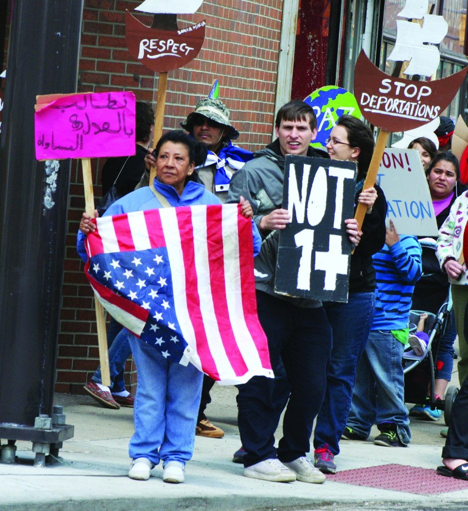 PHOTO BY CHUCK HOVEN Saturday, May 3, 2014; The Immigrant Justice Solidarity Rally and March organized by the Greater Cleveland Immigrant Support Network: Supporters of immigrant rights protest on the corner of Clark and W. 25 as they march through the Clark-Fulton neighborhood. The demonstrators called for an end to deportations and a more compassionate policy for immigrants and their families. 