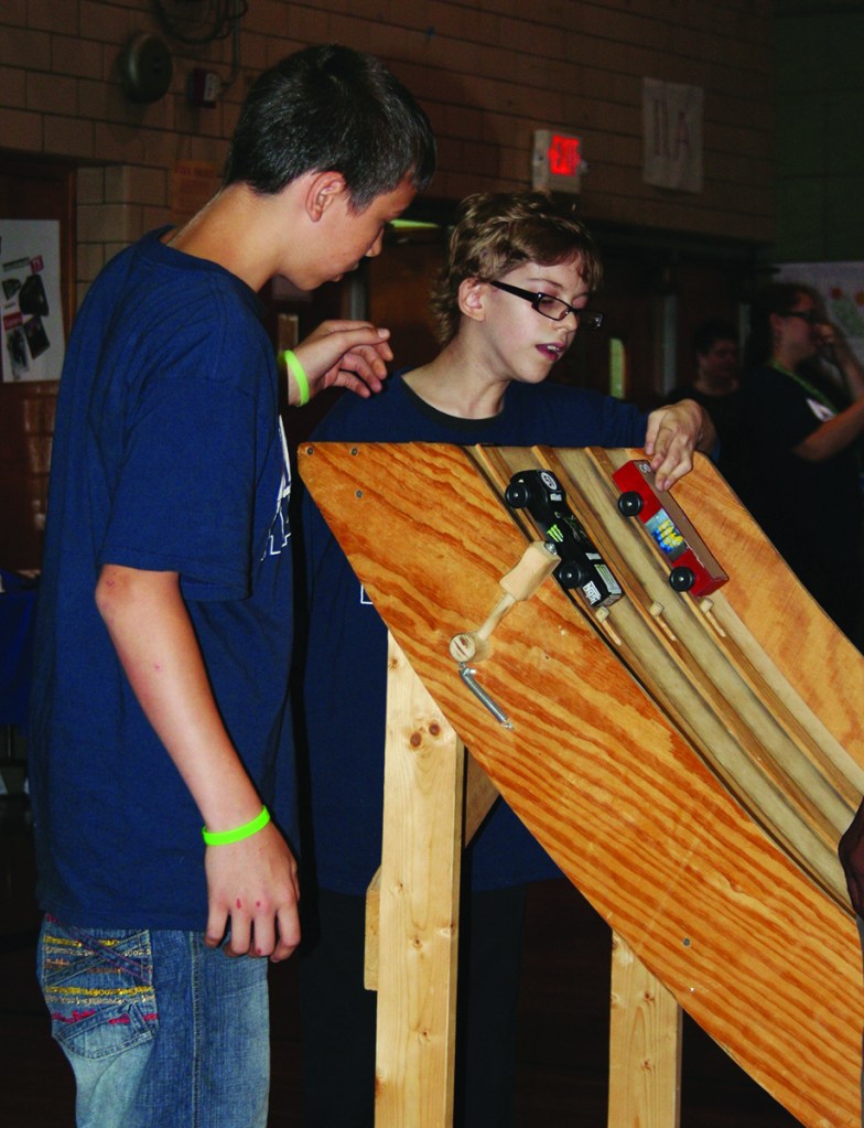 PHOTO BY DEBBIE SADLON Thursday, June 26, 2014, Max Hayes Career and Technical High School Take it to the MAX! Summer Camp 2014 Pinewood Derby Championship, 4600 Detroit Avenue: At the graduation ceremony for the summer camp students race pinewood cars they designed and created. Michael Doss and Phillip Jacobs place their cars on the track at the beginning of a race. 