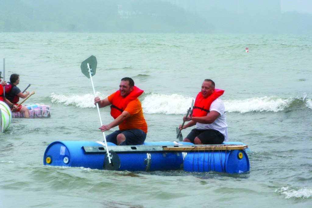 PHOTO BY DEBBIE SADLON Saturday, September 6, 2014, Great Lake Erie Boat Float, Cleveland Metroparks Edgewater Park: Fairview Hospital employees Bill MacKay and Aaron Matisak navigate their boat, Fairview’s Fabulous Floating Junk-It, through the waters of Lake Erie. The boat, which was made from barrels used to hold chemical treatment for Fairview’s Cooling Towers and other recycled materials from the hospital, was voted most seaworthy. 