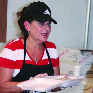 PHOTO BY CHUCK HOVEN Sunday, August 31, 2014; St. John Cantius Polish Festival, 906 College Ave: Caroline Sutowski serves up pierogies to guests at the festival. 