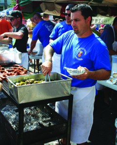 PHOTO BY CHUCK HOVEN Monday, September 1, 2014; St. Rocco Festival, 100th Year in Clark Fulton neighborhood: Paul Bellflower prepares Italian sausage for hungry festival patrons. 