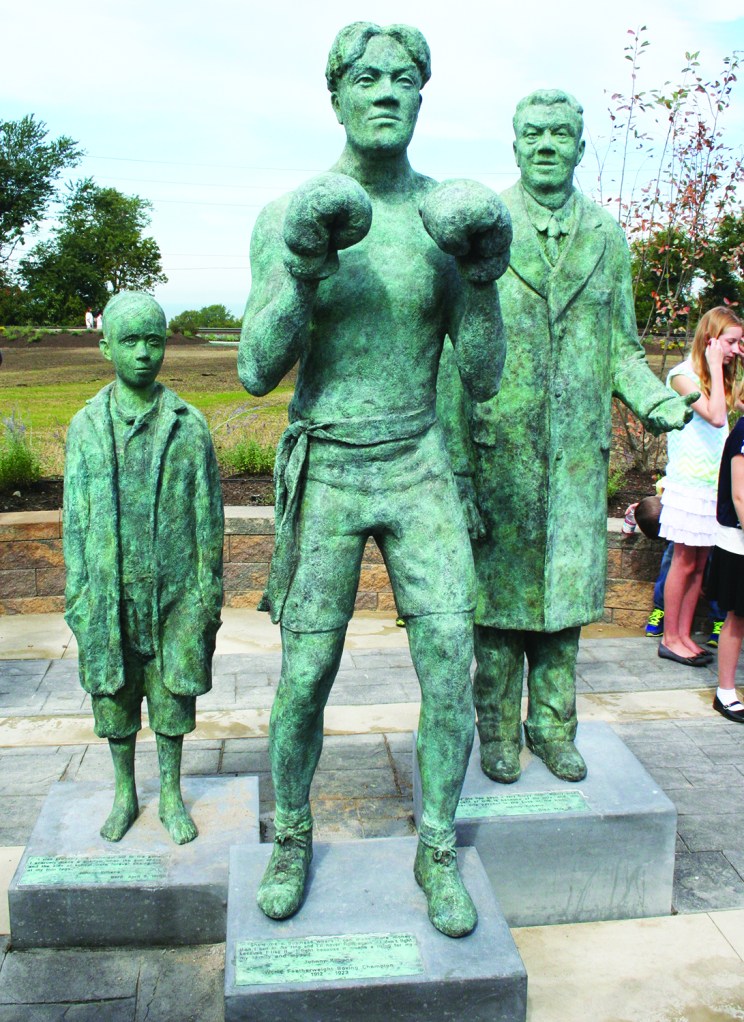 PHOTO BY ED TISHEL Sunday, September 28, 2014; The Irish American Archives Society’s dedication of the Johnny Kilbane Sculpture and Plaza, W. 74th and Fr. Frascati Drive, Battery Park: Johnny Kilbane: A Fighting Heart, a bronze sculpture mounted on limestone, depicts Clevelander Johnny Kilbane in three stages of his life: Kilbane as a young child who helped support his family after his mother died and his father went blind; Kilbane as a champion boxer who held the world featherweight title belt from 1912 to 1923; and Kilbane as a statesman who served as both an Ohio State Senator and as Cleveland Clerk of Courts.