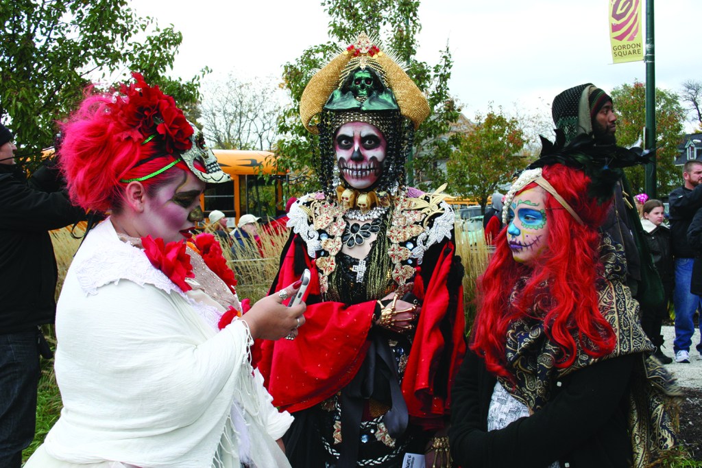 PHOTO BY DEBBIE SADLON Saturday, November 1, 2014; Dia De Muertos (Day of the Dead) celebration, Cleveland Public Theatre Parish Hall, 6205 Detroit Avenue: This family takes time out for a photo as they wait for the start of the Day of the Dead procession on Detroit Avenue.