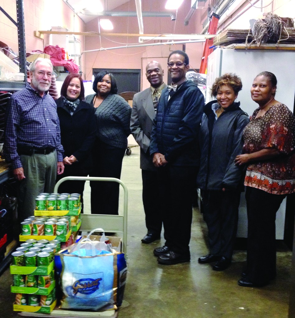 PHOTO BY OBED W. SHELTON October 2014; La Sagrada Familia Church, 7719 Detroit Avenue: Fr. Robert Reidy of La Sagrada Familia Church (far left) accepts a money and food donation from Clerk of Courts Earle B. Turner (3rd from right), and members of the employees’ committee “We Care”. The donation was made in the same church kitchen from which thieves stole food last June. From left to right; Fr. Robert Reidy, Marisellie Rivera (Human Resources Administrator), Shonda Jenkins (Supervisor Criminal Division), Dwight Lacey (Chief of Security) Earle B. Turner (Clerk of Courts), Delissica Crosby (Chief Deputy Clerk), and Mary Wooden (Chief Deputy Clerk).