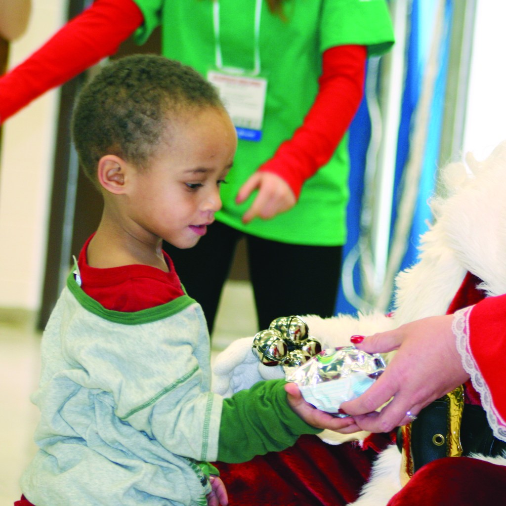 PHOTO BY CHUCK HOVEN Thursday, December 11, 2014; H. Barbara Booker School’s Holiday Musical Program, 2121 W. 67th Street: After visiting with Santa, this student accepts a gift from Mrs. Claus.
