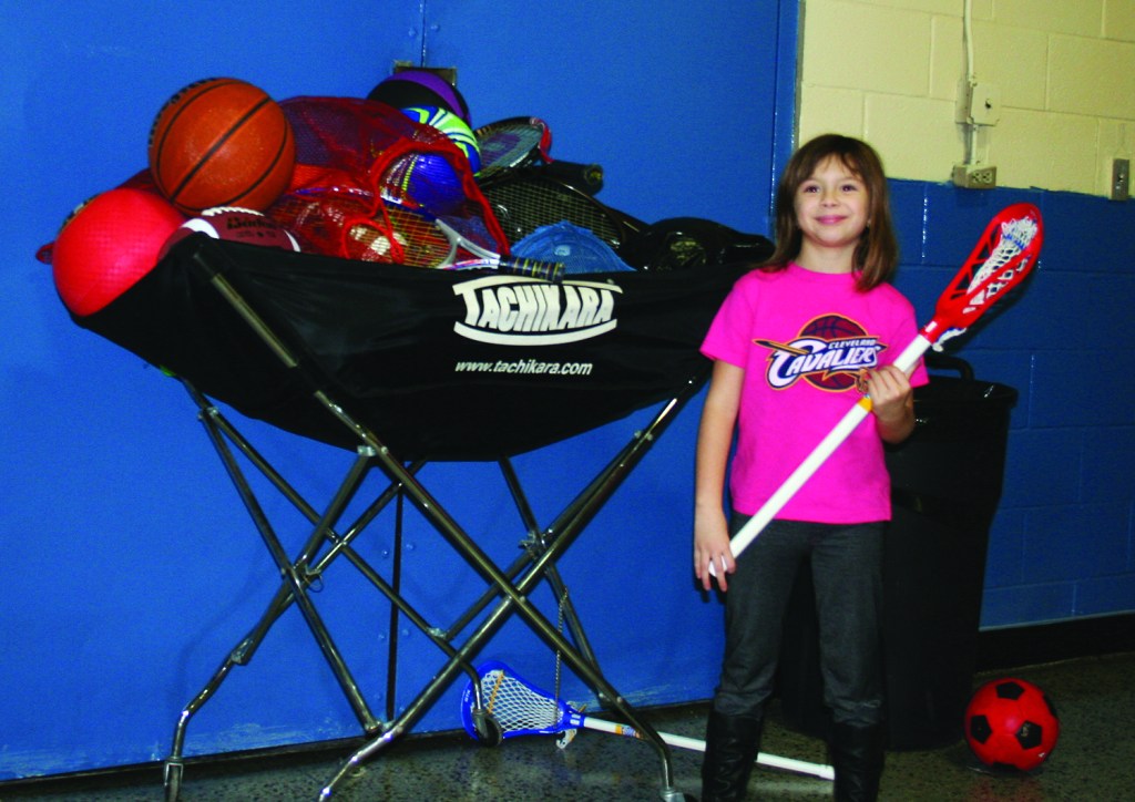 PHOTO BY CHUCK HOVEN Monday, December 8, 2014; Grand Reopening of the Hispanic UMADAOP Youth Center, 3115 Scranton Road: Izabella Hernandez, age 8, checks out the new sports equipment received by the Hispanic UMADAOP Youth Center from Keep Playing Cleveland as a result of a donation from Greg Zashin. Zashin, age 13. asked that instead of gifts at his Bar Mitzvah that donations be made to Keep Playing Cleveland.