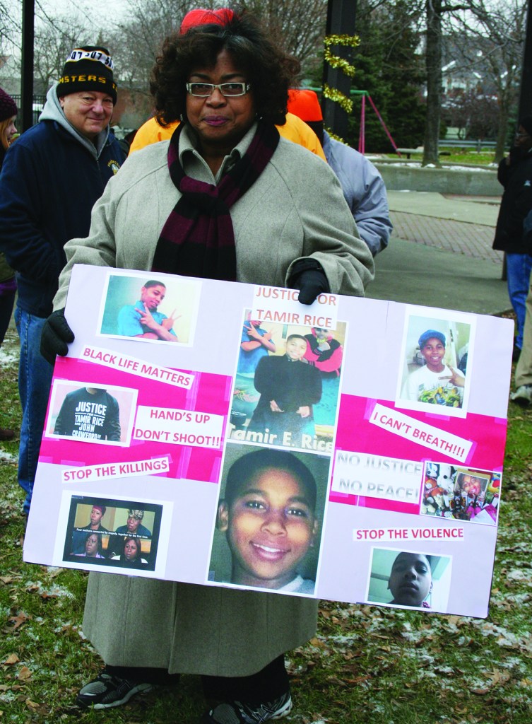 PHOTO BY DEBBIE SADLON Saturday, December 20, 2014; The Cleveland Ferguson Stance, Cudell Recreation Center, West Boulevard and Detroit Avenue: Laura Cowan holds a poster memorial to Tamir Rice, the 12 year old Cleveland boy who was shot by a police officer and killed on November 22nd near the spot where she is standing. People from Ferguson Missouri joined with Clevelanders to stand against police brutality and to honor the lives and memory of those who were killed by police. The group marched from Cudell to several West Side locations including the First Police District headquarters building. PHOTO BY HENRY SENYAK 