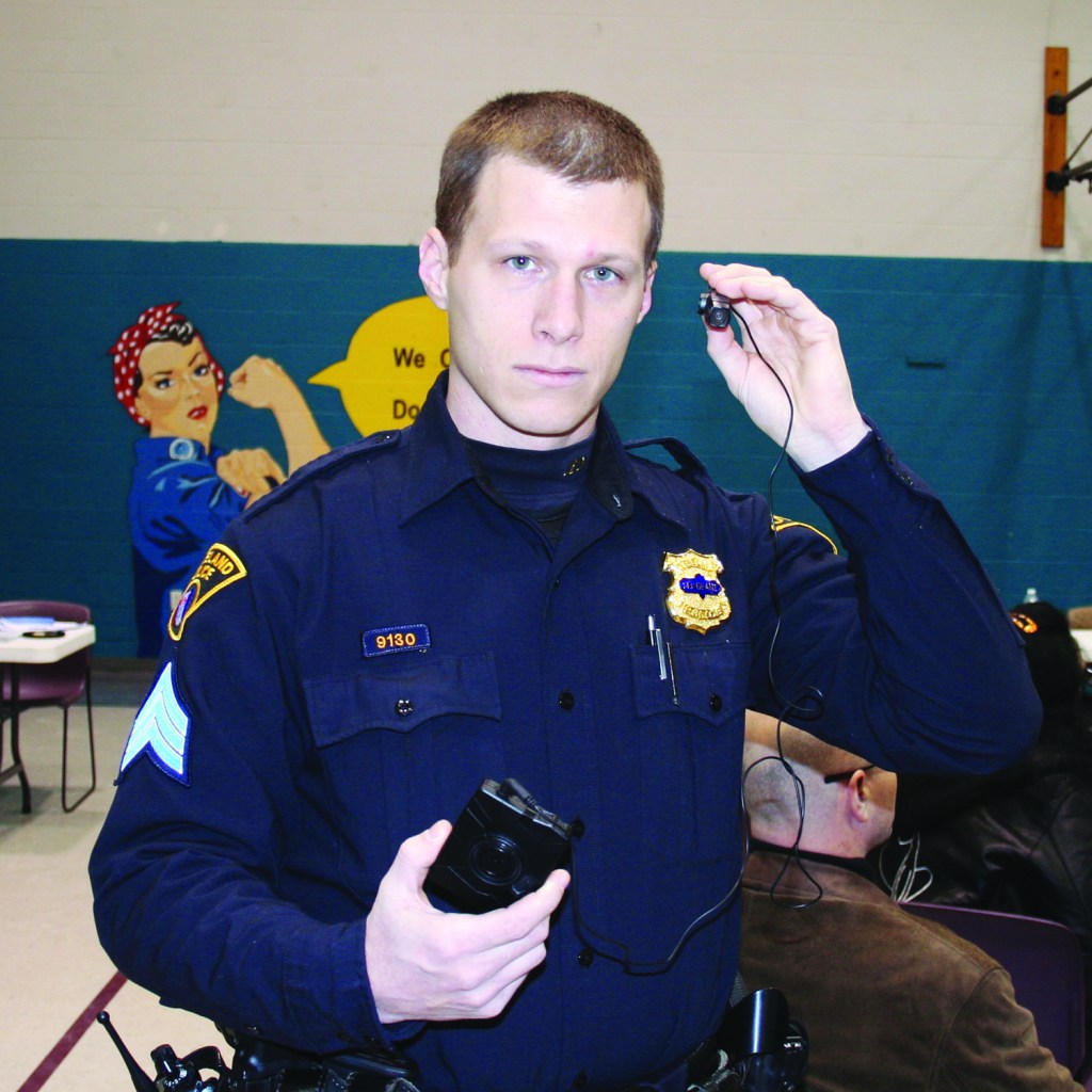 PHOTO BY CHUCK HOVEN Tuesday, February 10, 2015; Second District Community Relations Committee meeting; Applewood Center, 3518 W. 25th Street: Second District Police Officer Mitch Sheehan demonstrates the use of a clip on body-worn camera. 