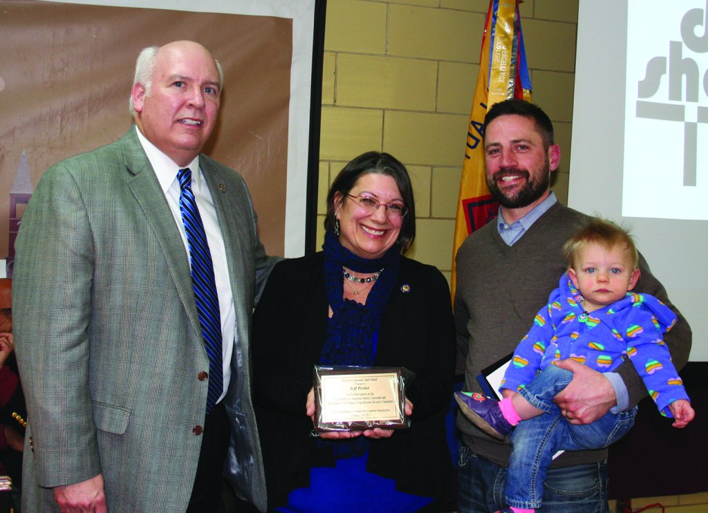PHOTO BY CHUCK HOVEN Thursday, February 26, 2015; Detroit Shoreway Community Development Organization 41st Annual Meeting, Our Lady of Mt. Carmel Church Pope John Hall: Jeff Pesler holds his child, Aidy, as he accepts the Community Spirit Award from State Senator Michael J. Skindell (D-23) and State Representative Nickie J. Antonio (D-13). Pesler helped to improve the area’s entertainment district and also is active in the West Clinton Block Club.