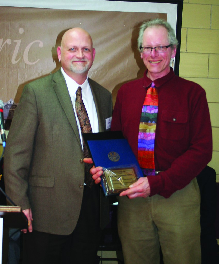 PHOTO BY CHUCK HOVEN Thursday, February 26, 2015; Detroit Shoreway Community Development Organization (DSCDO) 41st Annual Meeting, Our Lady of Mt. Carmel Church Pope John Hall: Brad Stemen accepts a Sustainability Award from DSCDO Executive Director Jeff Ramsey on behalf of himself and Jennifer Hilmer. Stemen and Hilmer are involved in an effort to create a gateway park and garden at the Madison Avenue entrance to the Greater Cleveland Regional Transit Authority W. 65th rapid transit station.
