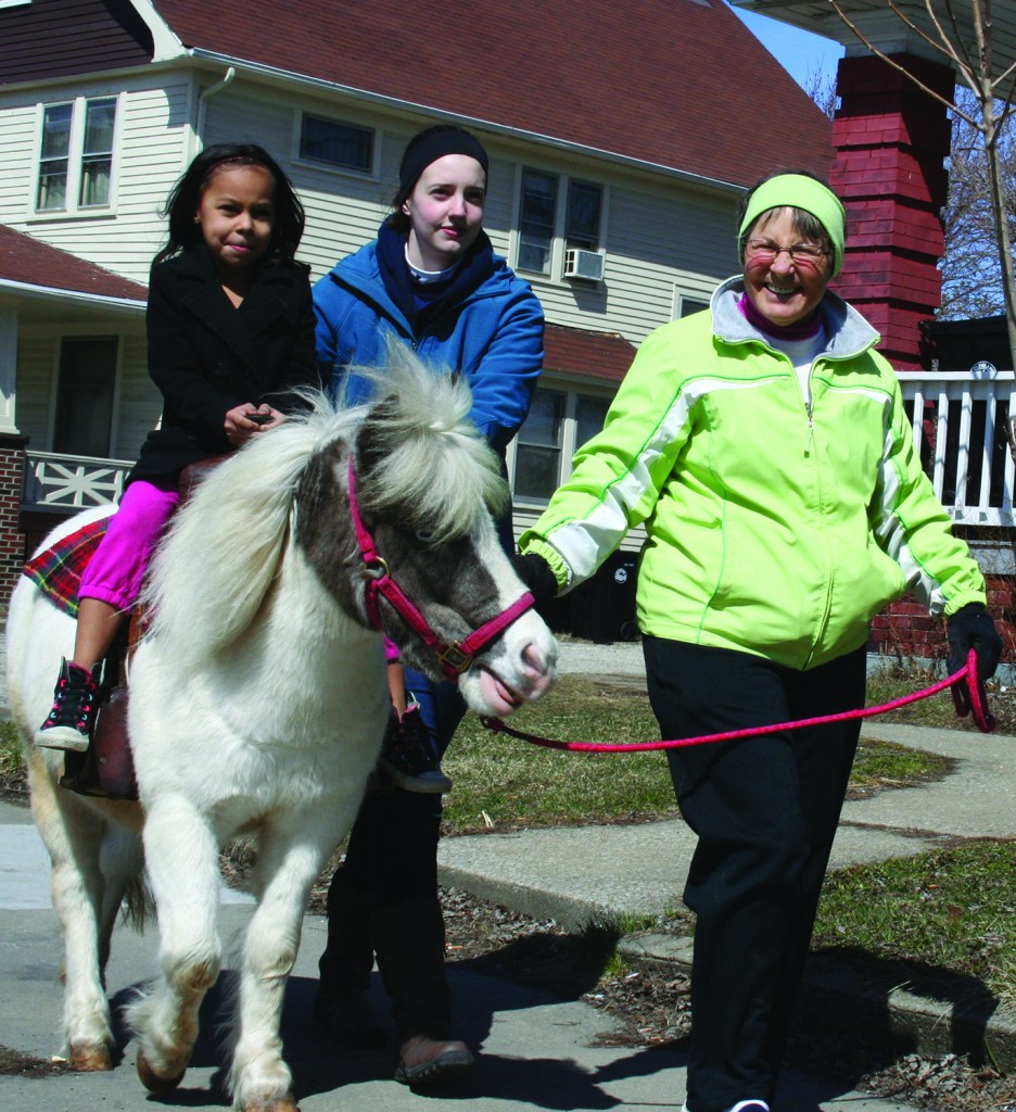 PHOTO BY CHUCK HOVEN Sunday, March 29, 2015; Palm Sunday Pony Ride, Denison Avenue United Church of Christ, 9900 Denison Avenue: Ahlivia Drdek, age 6, is on her first pony ride aboard Ariel, a pony from Coventree Farm. Susan Schnittke and Hayley Swinnerton from Coventree Farm walk along side.