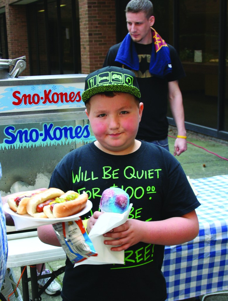 PHOTO BY DEBBIE SADLON Saturday, April 18, 2015; Hoops for Children’s Miracle Network, Luis Munoz Marin School gymnasium, 1701 Castle Ave: Walmart employees participate in a three-on-three basketball tournament to raise money for the Children’s Miracle Network. Kyle Padgett, age 8, of Wadsworth, Ohio, enjoys a snow cone. 