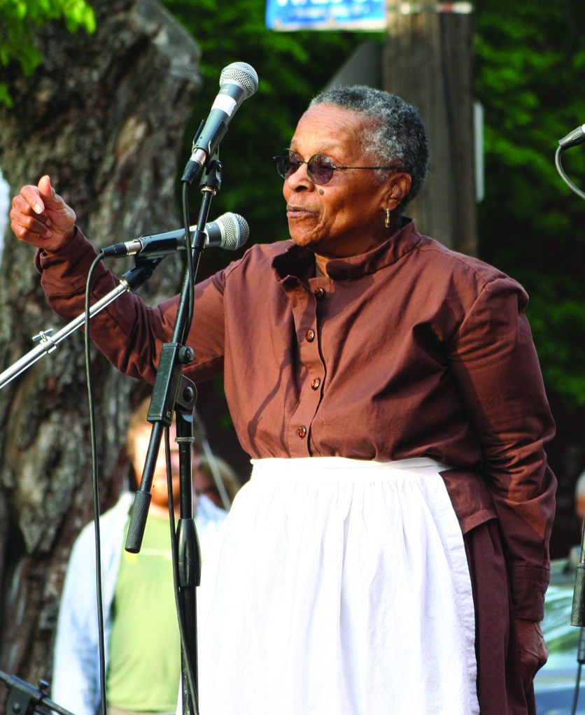 PHOTO BY CHUCK HOVEN Saturday, May 9, 2015; Station Hope Block Party, St. John’s Church, Church Avenue between W. 26 and W. 28: Joan Southgate tells the audience of the role of Cleveland, which had the code name “Hope”, in the Underground Railroad that “brought freedom seekers to freedom.” Southgate brought attention the history of the Underground Railroad by walking the 519-mile route from Ripley, Ohio to St. Catherine’s Ontario in 2002 at age 73. The Underground Railroad, once traversed by Harriet Tubman and others as they guided those escaping slavery in the Southern United States, included St. John’s Church among the Station Hope destinations.