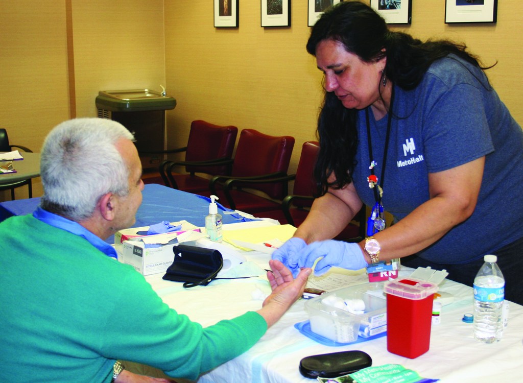 PHOTO BY DEBBIE SADLON Saturday, June 6, 2015, My MetroHealth, My Community Family Festival, MetroHealth Medical Center, corner of W. 25th and MetroHealth Drive: MetroHealth RN Mary Sanabria Simko checks the blood pressure and blood sugar level of West Side resident Ahmed Morad. Over 350 people attended the Family Festival with over 100 people taking advantage of free health screenings.