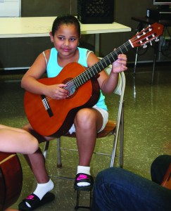 PHOTO BY DEBBIE SADLON Tuesday, July 21, 2015; Boys and Girls Club Walton School Site, 3409 Walton Ave: Jineliz Claudio demonstrates a new guitar skill to her guitar teacher, Mike McNamara, and to her sister, jomaliz Soto, who is also taking lessons. 