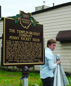 PHOTO BY CHUCK HOVEN Thursday, June 25, 2015; Templin-Bradley Co. Lofts ribbon cutting, dedication ceremony, and pubic art unveiling 5700 Detroit Avenue: Austin Poyer of Ohio History Connection unveils the Ohio Historical Marker which describes the history of the Templin-Bradley Company Penny Packet Seeds which it supplied to school gardening programs. The program began as a partnership with the Cleveland Public School’s Horticultural Program and spread to student gardening groups in cities throughout the nation. 