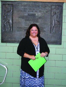 PHOTO BY DEBBIE SADLON Friday, June, 26, 2015; Max Hayes High School, 4600 Detroit Avenue: Max Hayes’ new principal, Kelly Wittman, stands in front of the dedication plaque for Max Hayes High School dedicated on October 29, 1957. Wittman hopes the plaque will be moved to the new Max Hayes at W. 65th and Walworth in time for the August 17th opening of the new school year.