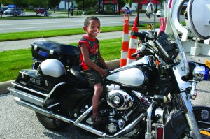 PHOTO BY DEBBIE SADLON Tuesday, August 4th, 2015; National Night Out Against Crime, Steelyard Commons: Quincy Johnson, age 5, mounts a police motorcycle. 