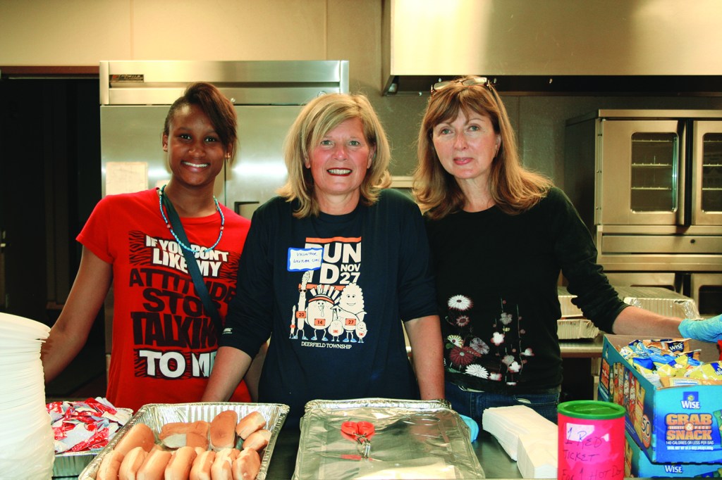 PHOTO BY DEBBIE SADLON Saturday, September 12, 2015; the Bridge Beats and Treats Festival, West Side Community House, 9300 Lorain Avenue: Volunteers (L-R) Mirakale Anthony, Karla Lux and Pennie Gray serve hot dogs to those attending the festival. 