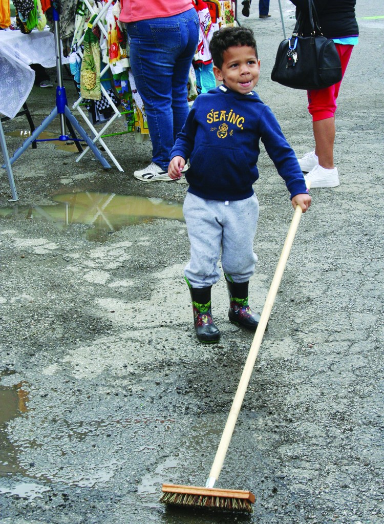 PHOTO BY DEBBIE SADLON Saturday, September 12, 2015; La Gran Fiesta, last La Placita Cleveland of the summer series of open air markets, US Bank Parking Lot, W. 25th and Clark Avenue: Mason Still, age 3, helps the cleanup crew at the last festival.   