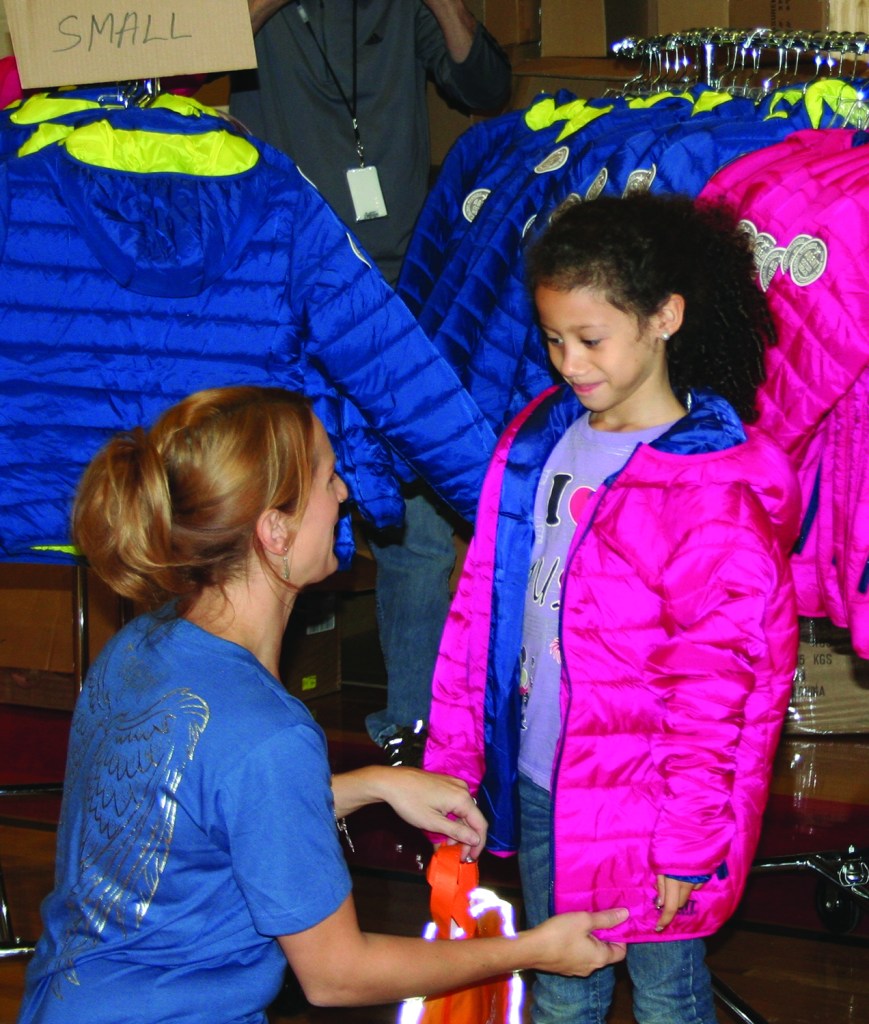 PHOTO BY CHUCK HOVEN Saturday, October 17, 2015; Coat Giveaway, Thomas Jefferson International Newcomers Academy, 3145 W. 46th Street: Lindsay Pavlich, Executive Agent of Agent Outwear, passes out coats to children from the Thomas Jefferson Newcomers Academy. Pavlich says her company, based in the city of Detroit, donates one coat to charity for every coat it sells. She says Continuum Energy, a natural gas supplier, helped to sponsor the coat giveaway. The Newcomers Academy at Thomas Jefferson has many students new to Cleveland that arrived here from countries all over the world. Many of the students have never lived in a cold climate.