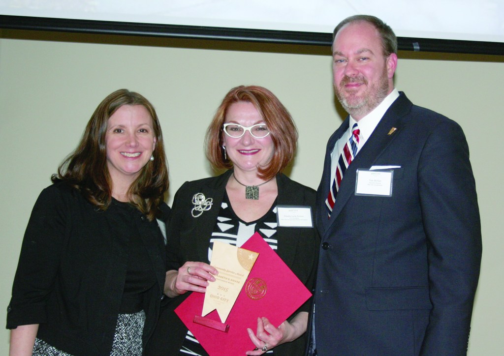 PHOTO BY CHUCK HOVEN Tuesday, March 22, 2016, Ohio City Incorporated (OCI) Annual Meeting, Urban Community School, 4909 Lorain Avenue: Providence House Chief Executive Officer Natalie Leek-Nelson (Center) accepts a Community Service Award on behalf of Providence House for its Elizabeth House Project, a 24-hour medical wellness nursery. Presenting the award are OCI Board President Erika McLaughlin (left) and OCI Executive Director Tom McNair (Right). 